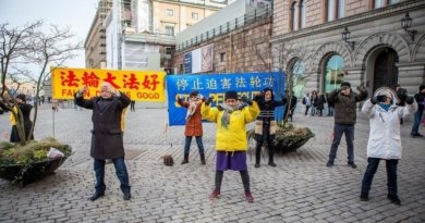 Практикующие выполняют упражнения на Монетной площади в Стокгольме. На жёлтом плакате написано «Фалунь Дафа – великий», на синем – «Остановить преследование Фалуньгун»