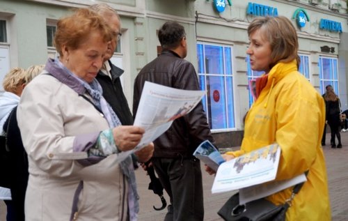 На Арбате в День города Москвы. Прохожие знакомятся с информационными материалами Фалуньгун. 2016 г. 