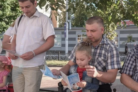 Зрители читают буклеты Фалуньгун