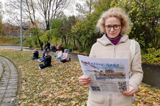 Напротив китайского посольства в Москве. На заднем плане последователи Фалуньгун выполняют медитацию; на переднем плане – прохожая читает инфоматериалы Фалуньгун