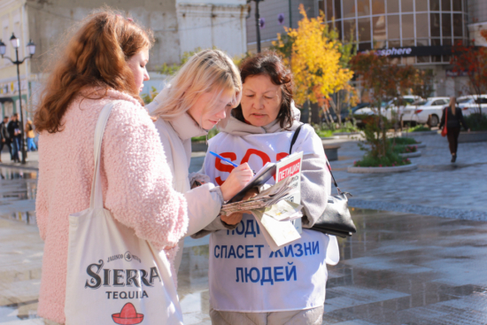 Сочувствующие подписывают Петицию против принудительного извлечения органов у последователей Фалуньгун