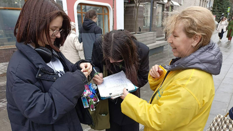 Девушка подписывает петицию, чтобы злодеяния по извлечению органов у живых людей прекратились