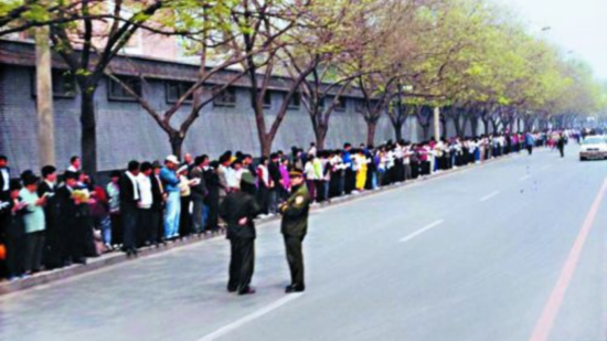 Практикующие Фалуньгун стоят вдоль улицы Фую в Пекине