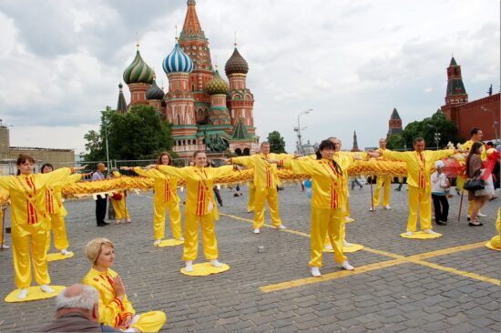 Группа людей в традиционных желтых костюмах на Красной площади в Москве
